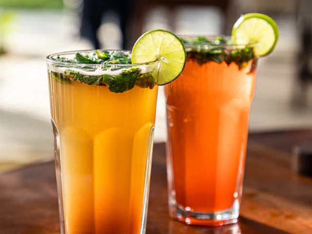 Deux mocktails glacés garnis de citron vert et de menthe