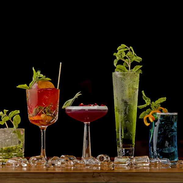Une rangée de boissons colorées garnies de fruits et d’herbes